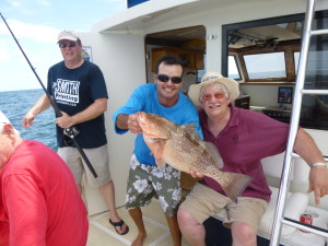 Left to Right: Gary Smith, Captain Steve Skevington and Dennis Macalister holding a 25-inch Red Grouper caught in "Paradise."